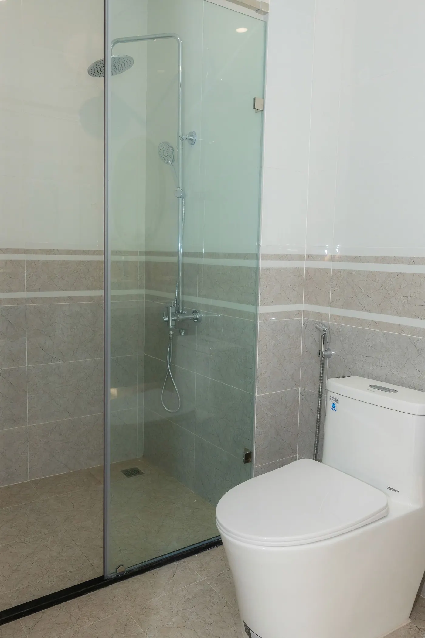 Clean modern bathroom with a frameless glass shower enclosure and wall-hung toilet